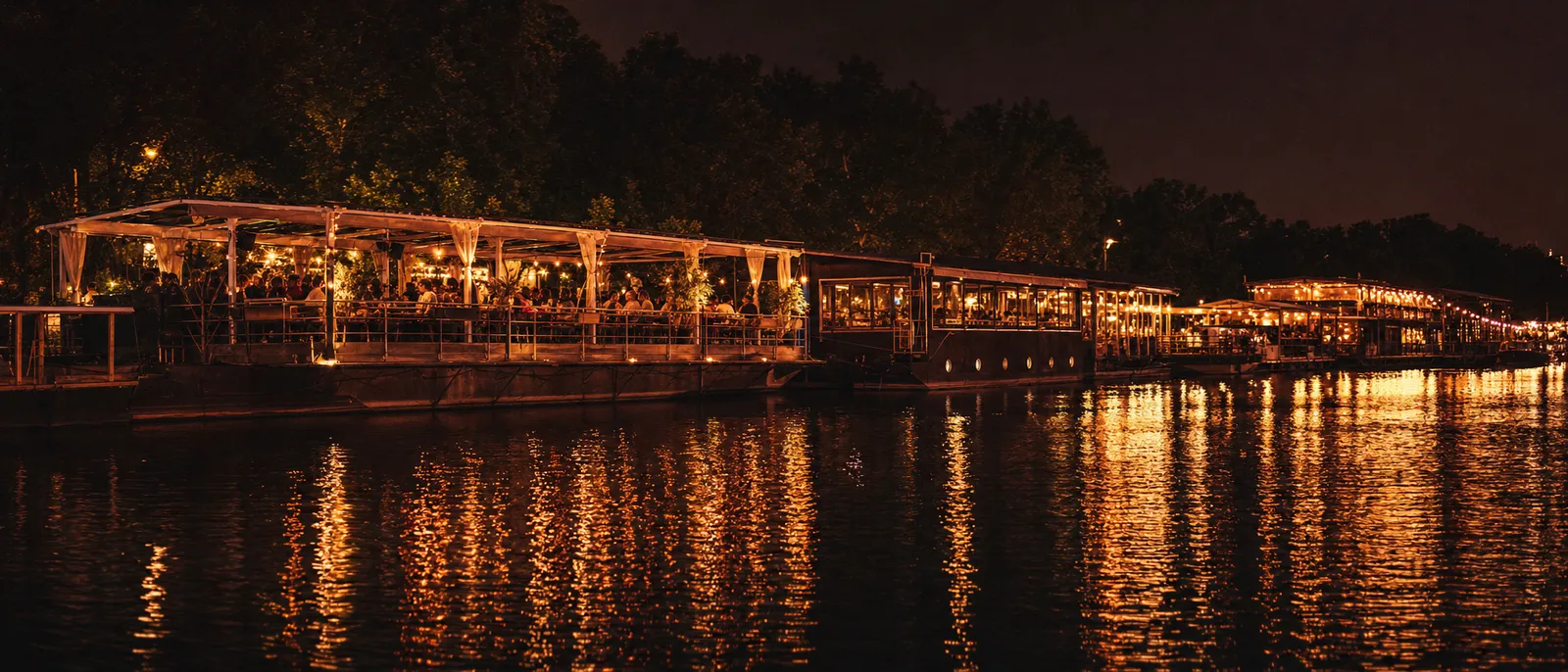 Illuminated floating river clubs on the water at night